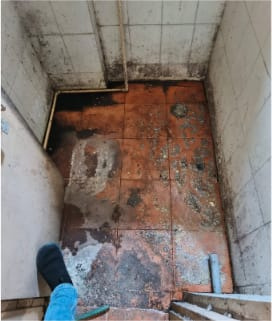 Damaged bathroom floor during assessment